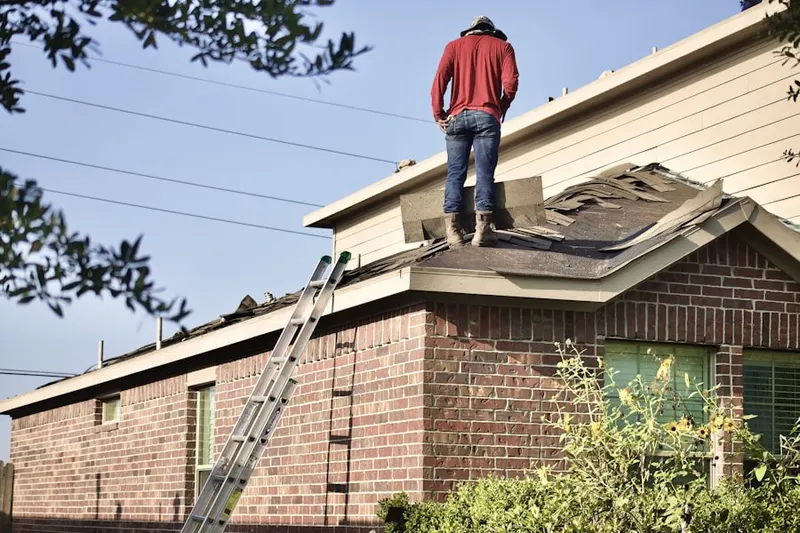 Professional roofer working on a residential roof in Elysian